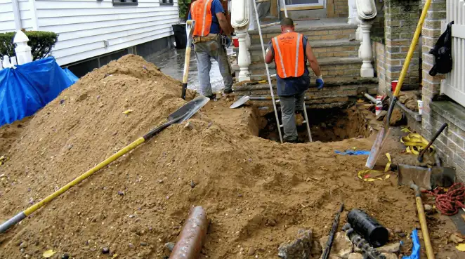 Contractors performing foundation protection and exterior drainage excavation near residential home steps in Marietta, GA